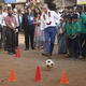 Prince William plays with a football as Kate watches during their visit to a slum in Mumbai on Apr. 10, 2016.